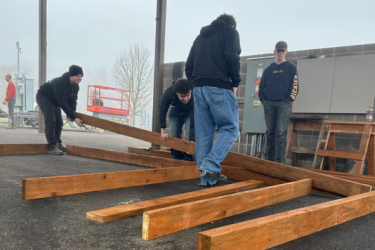 Students moving construction wood