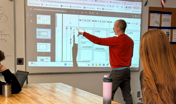 Teacher pointing to a construction plan