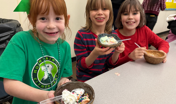 Three students eating ice cream at a table