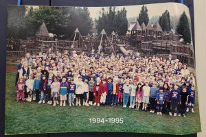 Students and staff in front of a playground