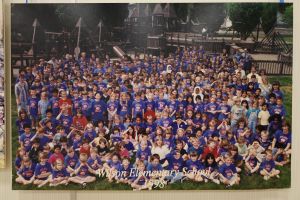 Students and staff in front of a playground